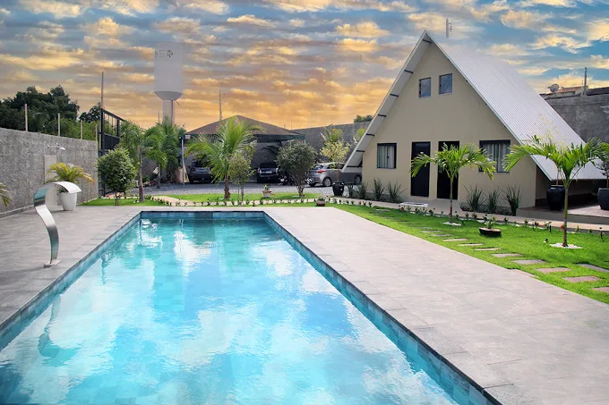 Área externa do Espaço Verde Eventos, com piscina e jardim ao entardecer